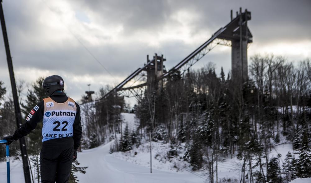 A ski jumper in competition stands before the jumps.