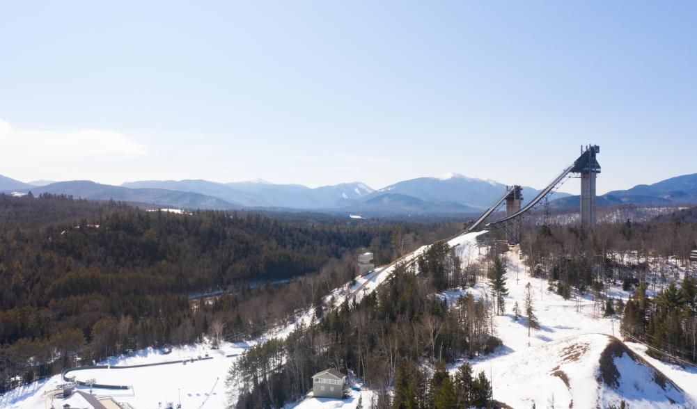 An aerial view of Olympic ski jumps with Adirondack Mountains beyond.