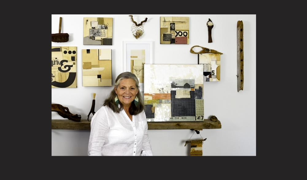 A woman stands with her collage artworks.