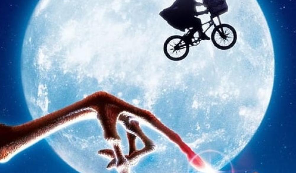 A graphic from the movie E.T. the extra-terrestrial, showing the moon as a backdrop to Elliott riding his bicycle with E.T. in the basket