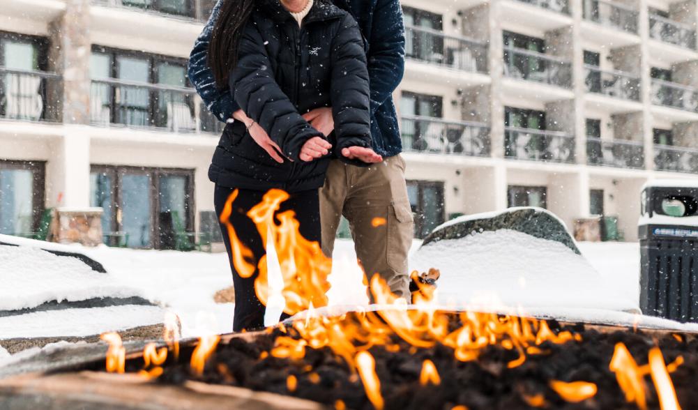 a couple gets cozy by a campfire.