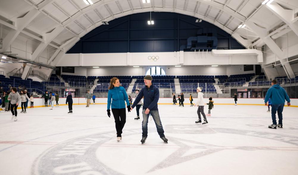 a couple skates in the middle of an ice skating rink.