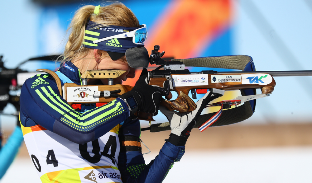 A female biathlete takes aim in a competition.