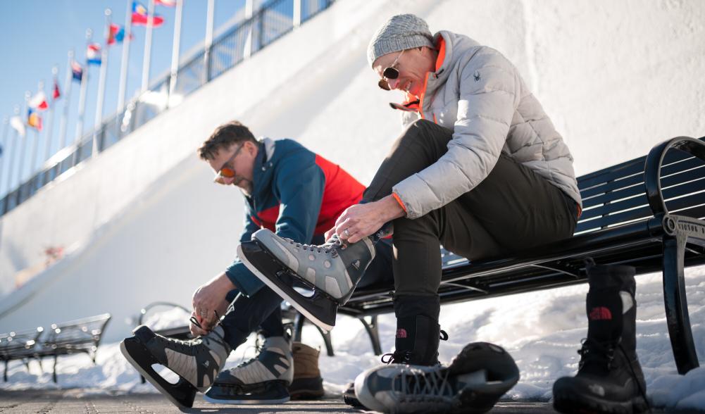 two friends lacing up skates to play outside.