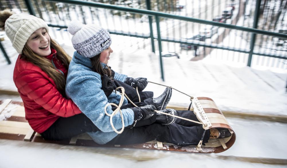 two girls on a toboggan slide down a 30 foot chute