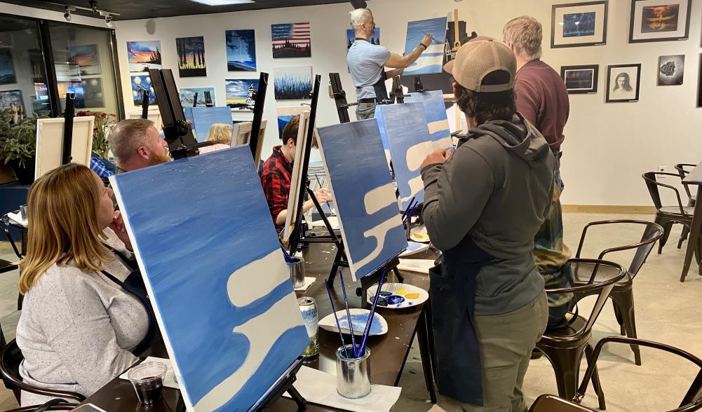 group painting the water on their canvases