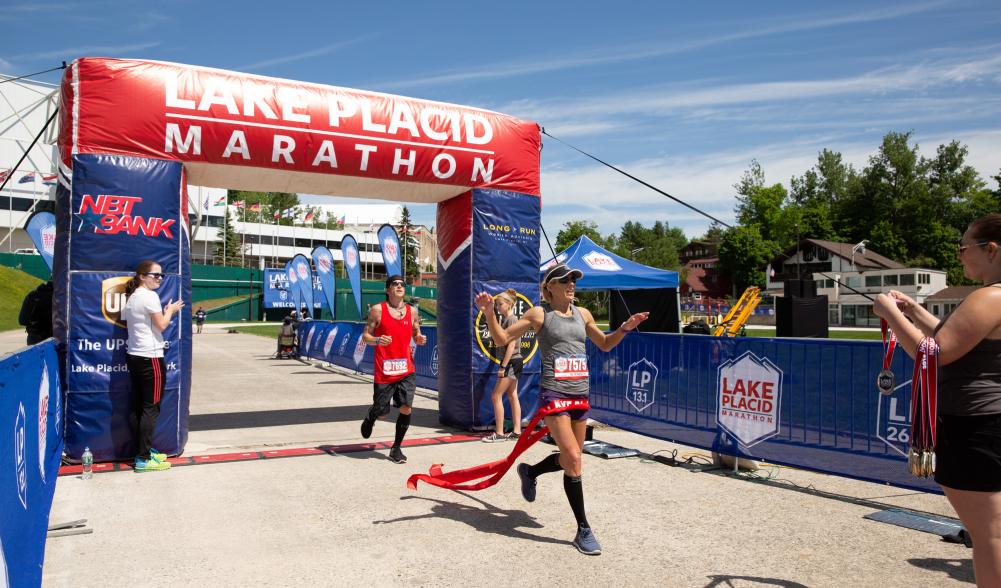 A runner crosses the finish line at Lake Placid Marathon and Half Marathon