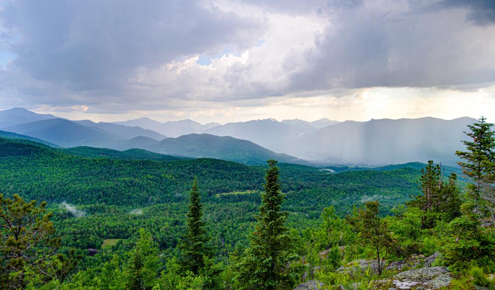 an aerial view of the green mountain range of Lake Placid in Summer.