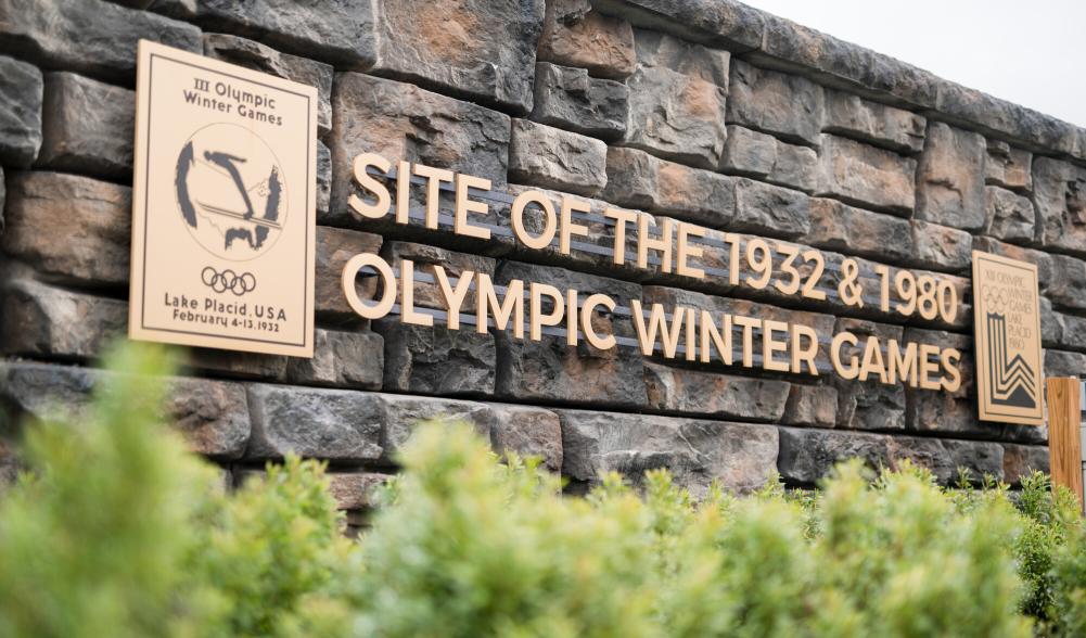 A stone and metal sign signifying the site of the 1932 and 1980 Winter Olympic Games