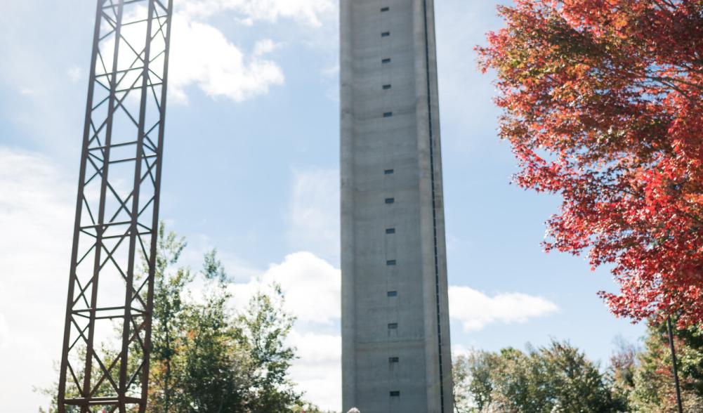 A photo of one of the ski jumps at the Olympic Jumping Complex in Lake Placid, with fall foliage in the distance