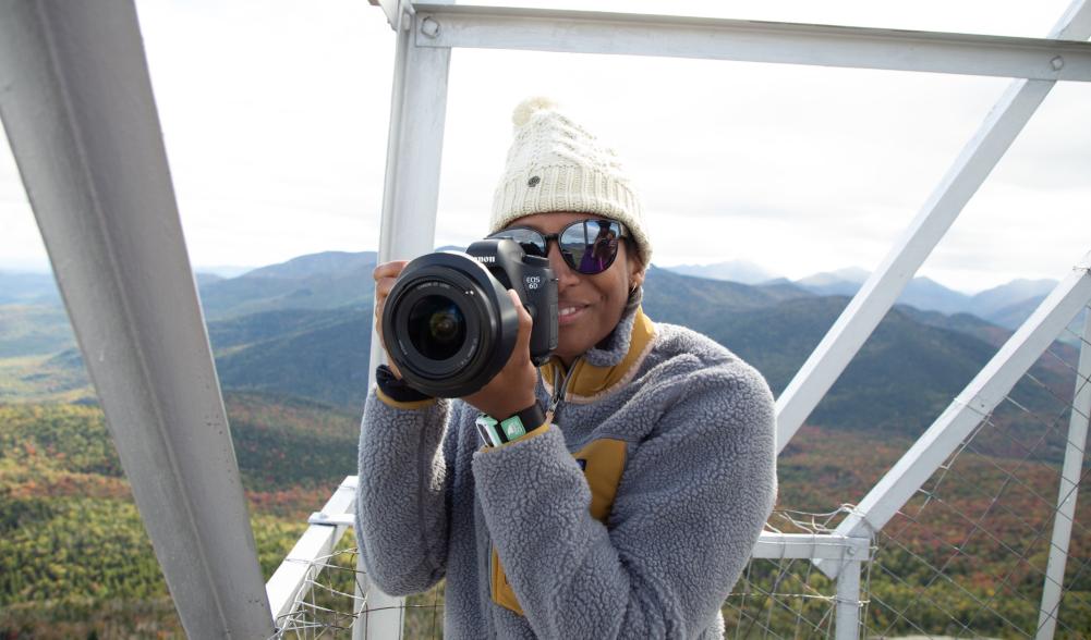 A woman takes a picture in a fire tower.