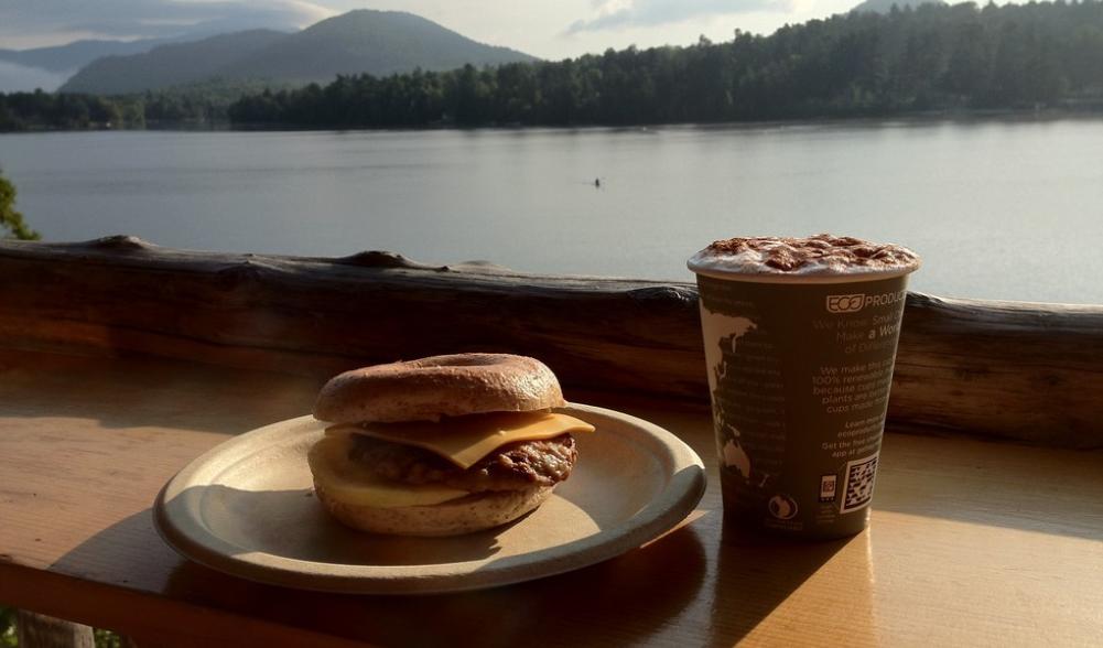 A breakfast sandwich and coffee overlook Mirror Lake.