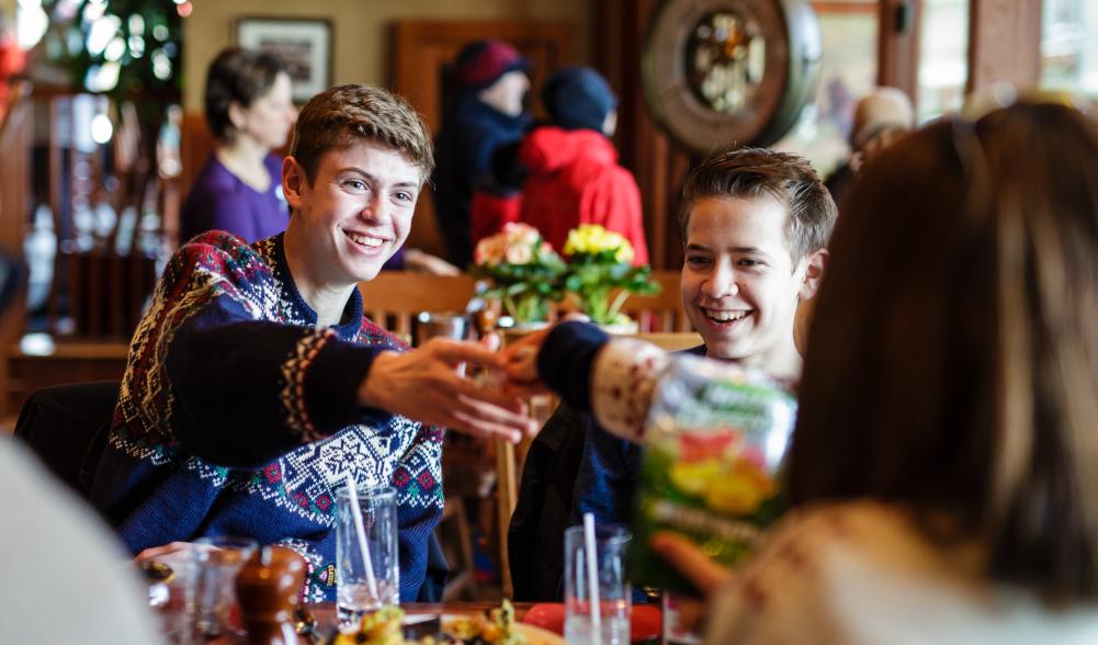 A family cheers drinks at dinner at a restaurant.