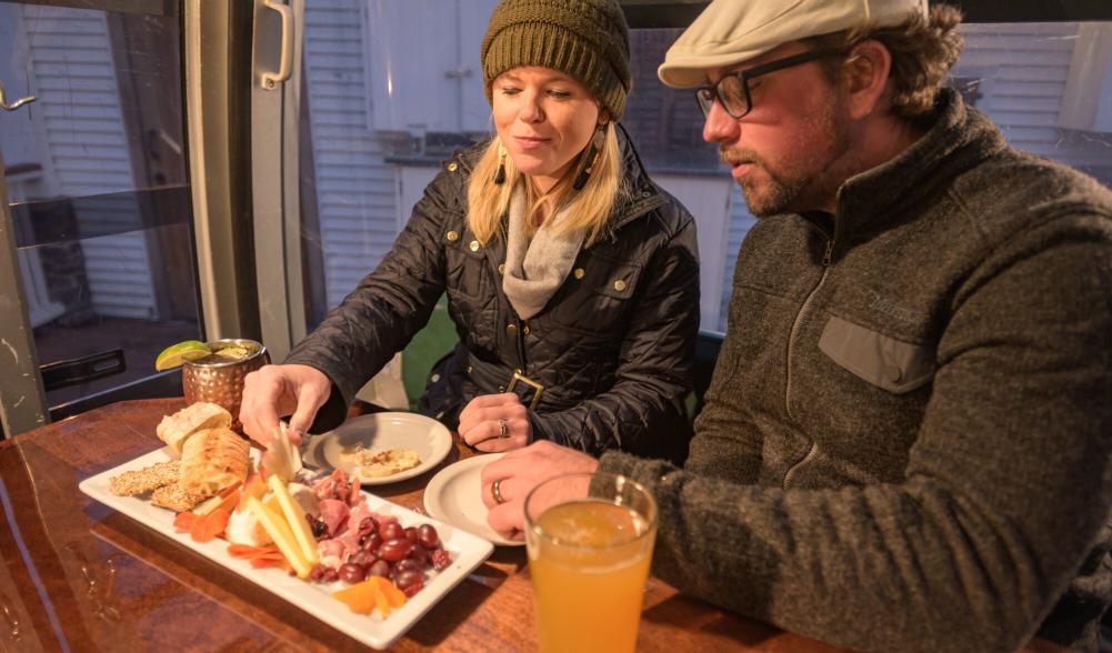 A man and woman share a charcuterie board.