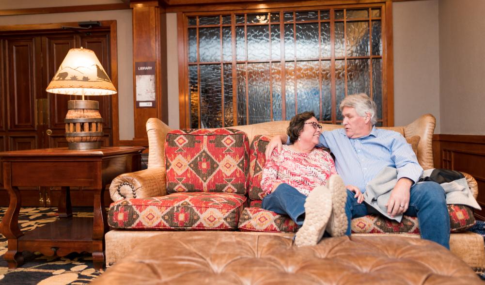 A couple relaxes on a couch in a luxury suite in one of Lake Placid's hotels