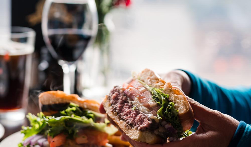 A woman holds a burger to eat.