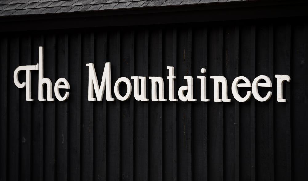A white sign on a black background that says "The Mountaineer"