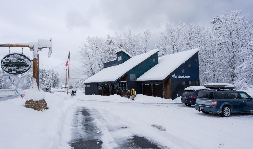 A few people walk into a snow-covered gear shop