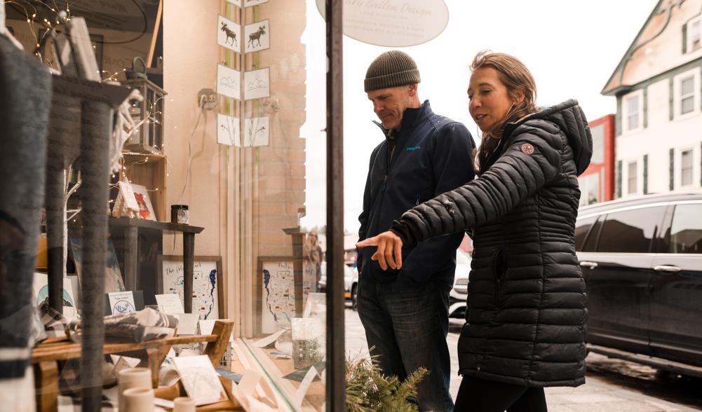 A man and woman window shop in winter.