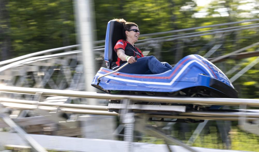 A woman speeds down a rollercoaster track in a cart.