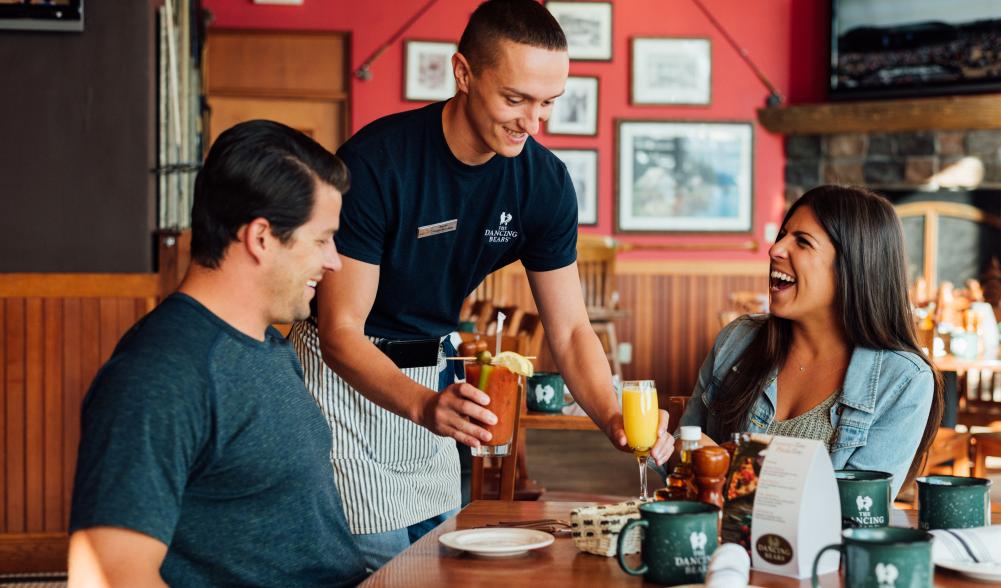 A man and woman order food at a cozy restaurant.