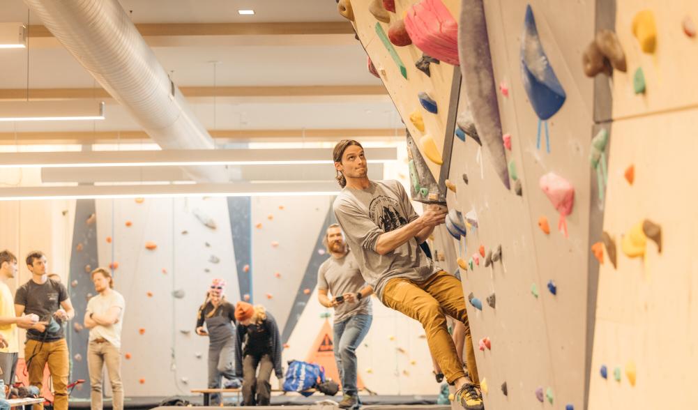 A large group of people bouldering in a climbing gym