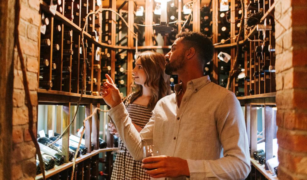 A man and woman shop for wine.