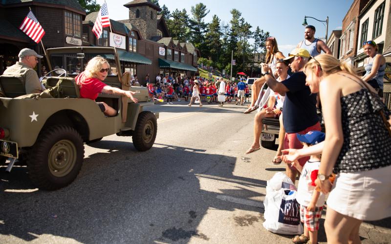 Car drives past parade crowd on Main Street in Lake Placid