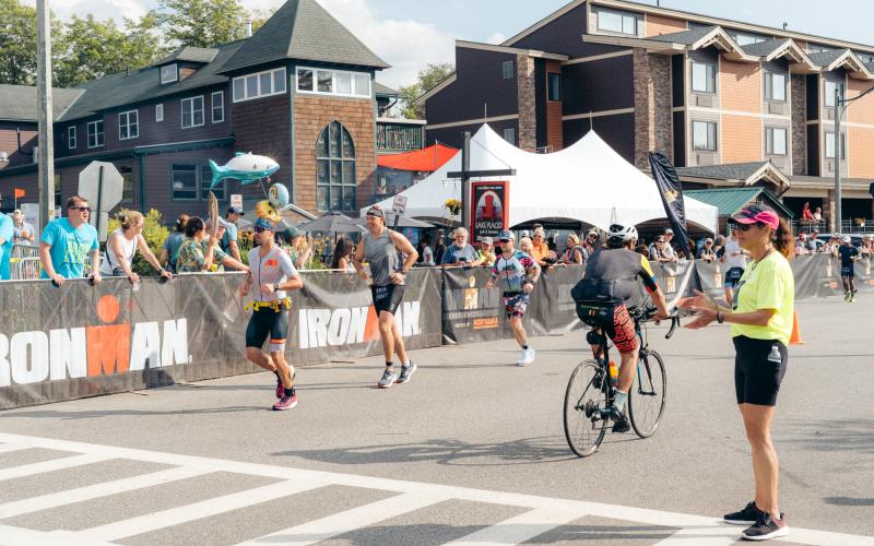 Ironman bikers and runners passing on the road