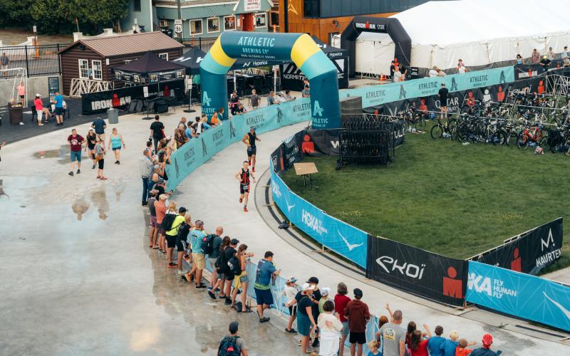 Ironman athletes running on oval with spectators watching