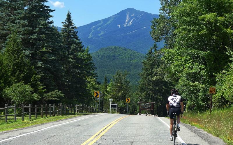 Cyclist on road with Whiteface Mountain in distance