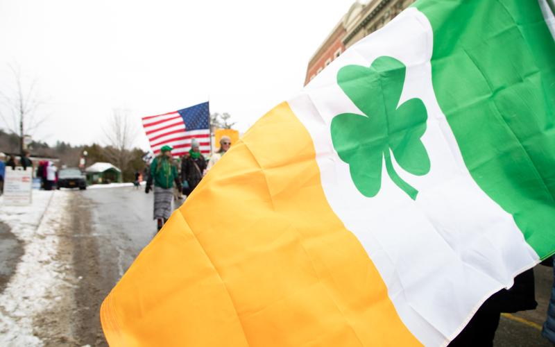 And Irish flag with a clover flown in front of an American flag