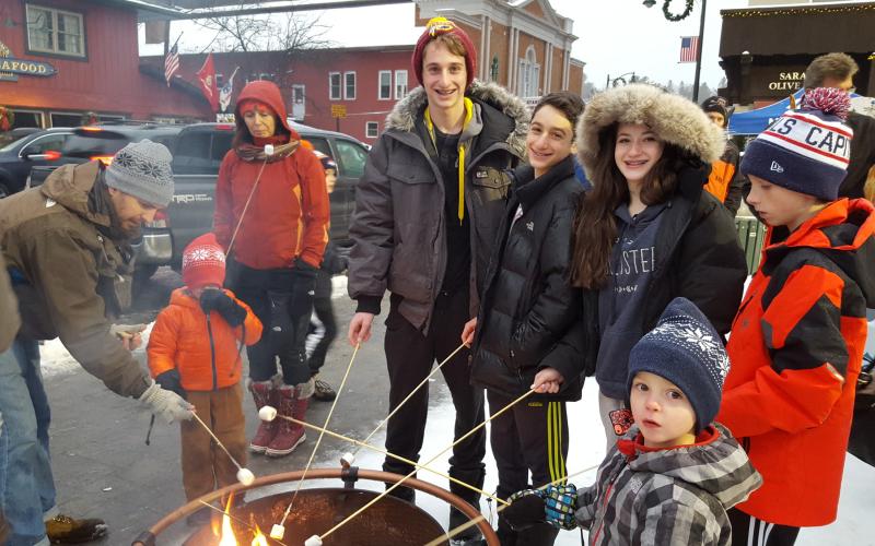 Group of young people roast marshmallows on Main Street.
