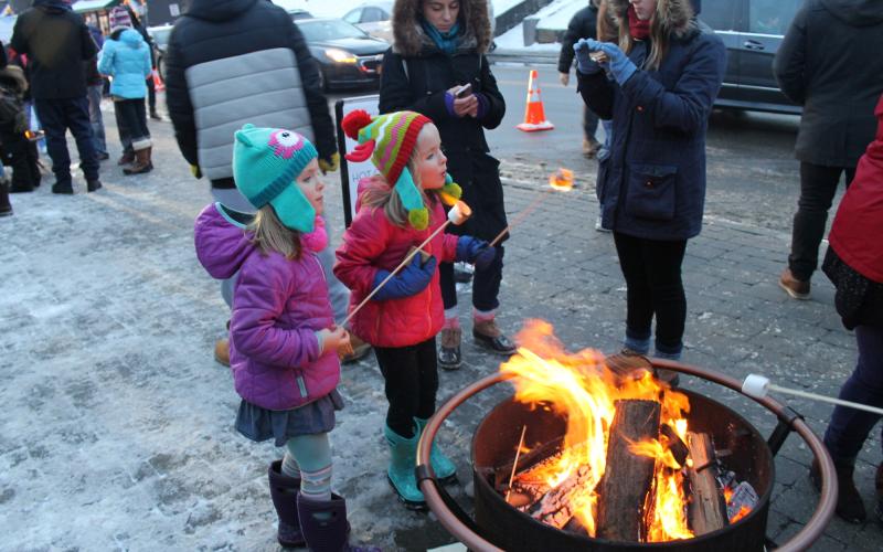 2 children roast marshmallow on Main Street