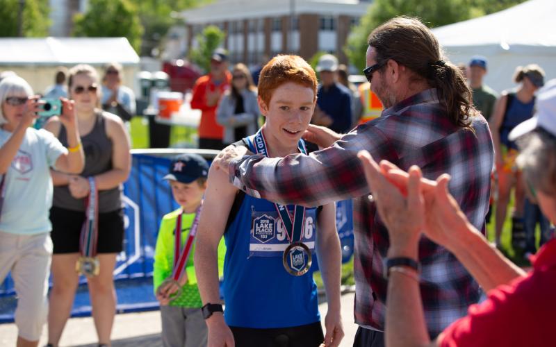A father puts a finisher medal on this sun