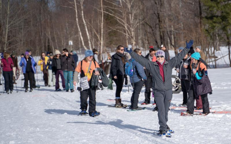 Snowshoers and cross-country skiers on a trail.