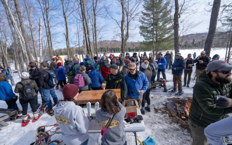 Cross-country skiers getting beer along a trail.