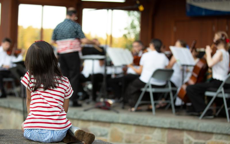 Child watches a band play in the bandshell