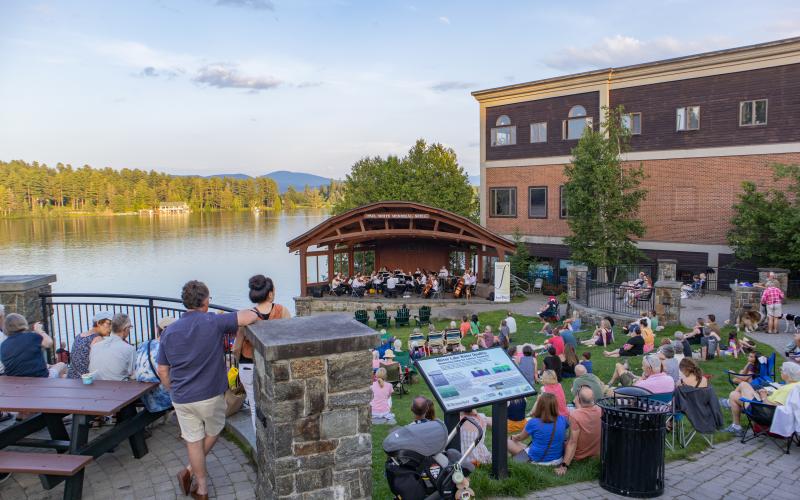 Park concert overlooking green with mountains and lake surrounding Credit to: Jacob Rushlow