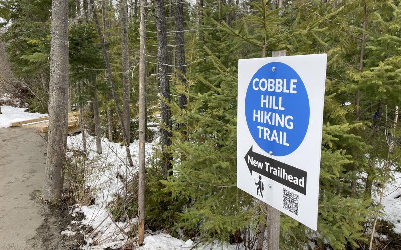 A blue and white sign for the new Cobble Hill Hiking Trail.