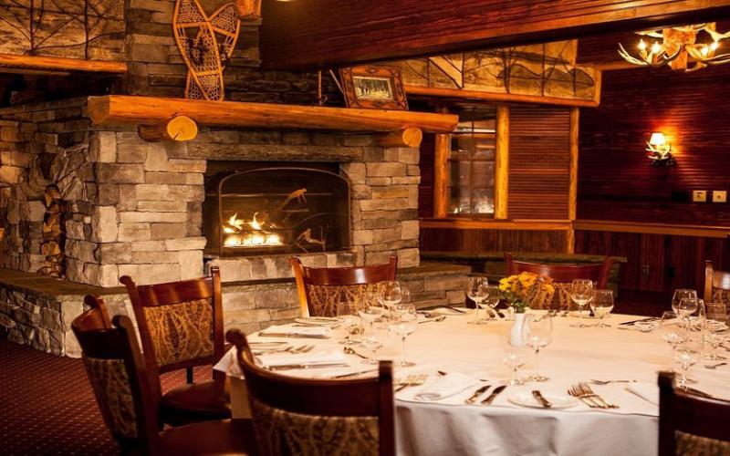 Beautifully appointed dining table in the Wikoff room with grand stone fireplace and large wood beams
