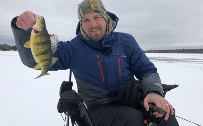 Man holding perch on the ice