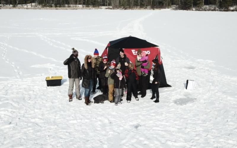 Family on the ice next to shanty