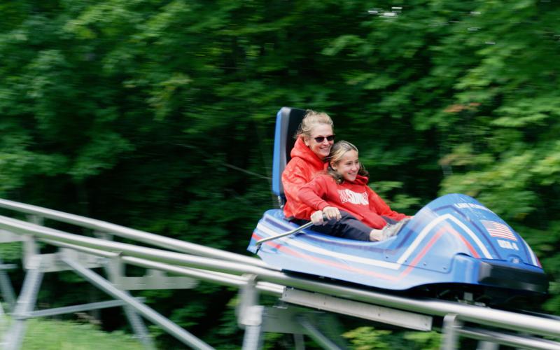 Mother and child ride the Cliffside Coaster