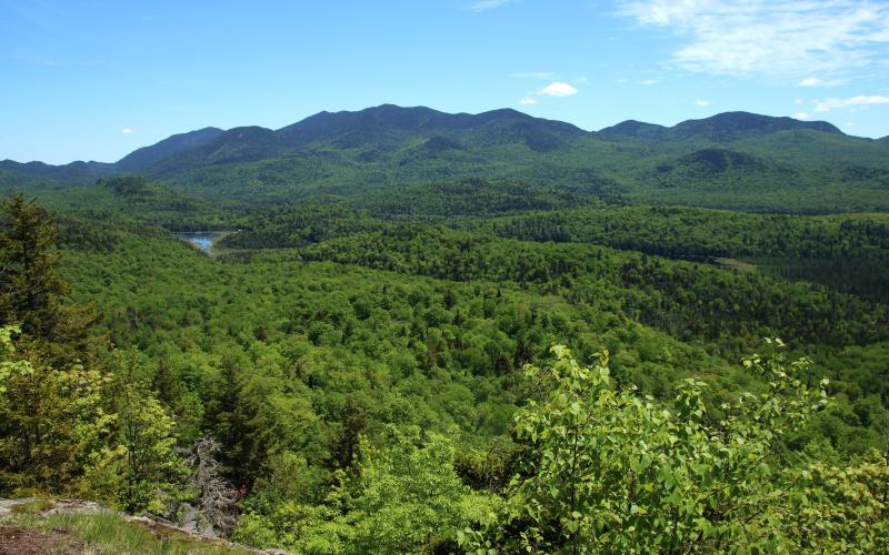 The large valley visible from the summit leads right to a mountain range.