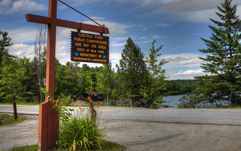 A yellow and brown sign marking a campground.