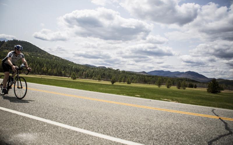 A cycler rides down a road