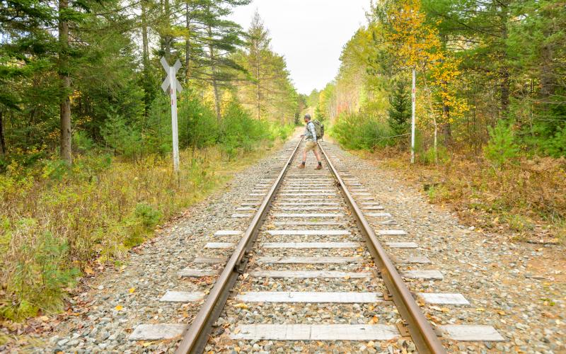 A hiker walking across a railroad