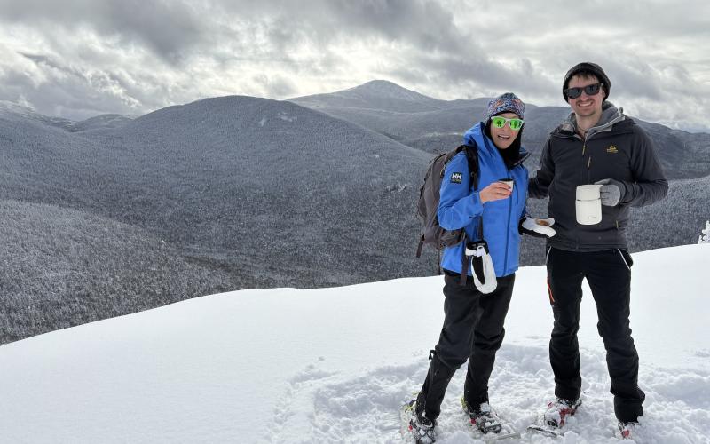 Mountaineers throw their hands in the air in celebration after ascent
