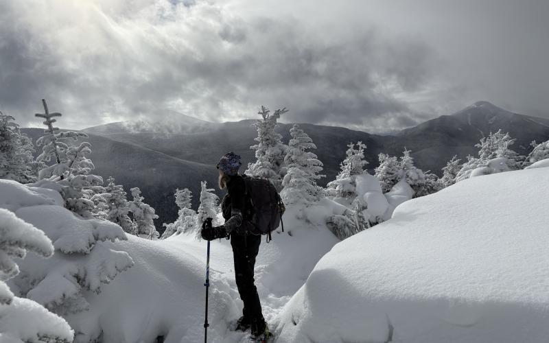 Snowshoer takes in the mountains in the distance